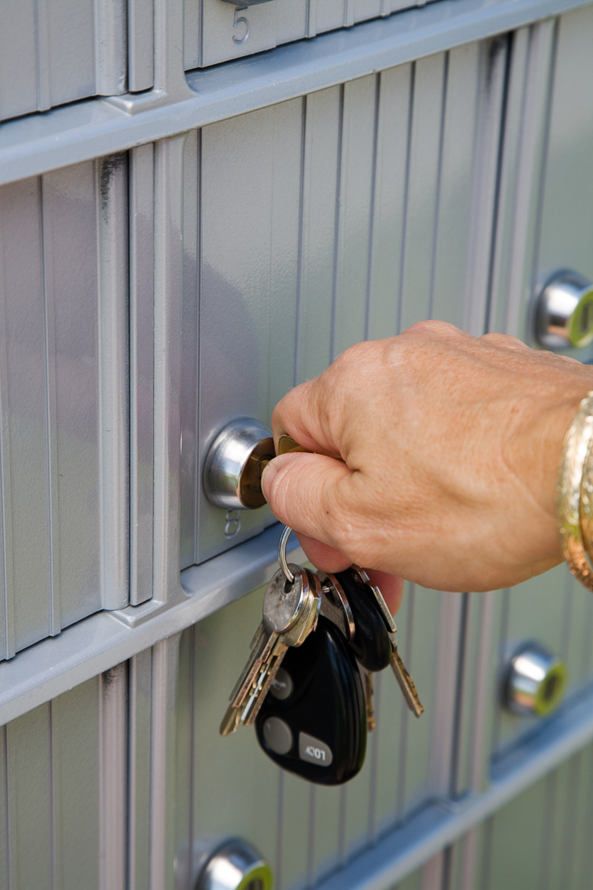 person opening mailbox with key